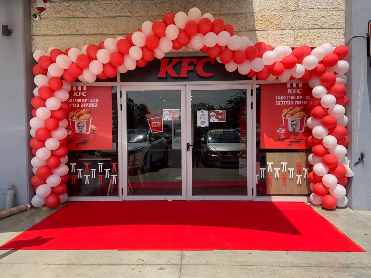 שער בלונים בכניסה לחנות KFC עם שטיח אדום
